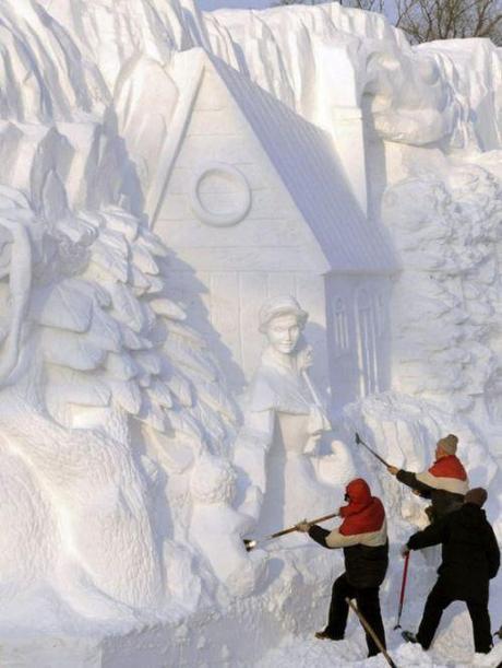 Workers shape a snow sculpture at the Harbin International Ice and Snow Festival in Harbin,