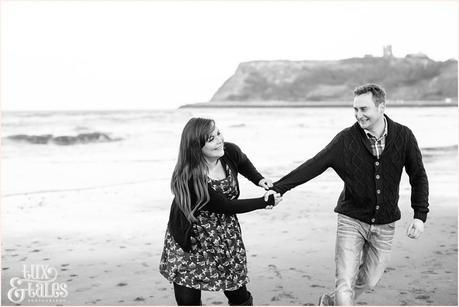 Fun couple play at the beach in scarborough engagement shoot