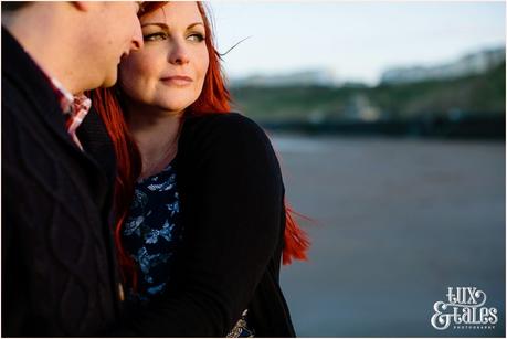 Couple snuggle in afternoon light in Scarborough engagement shoot