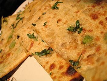 Picture of aloo (potato) paratha lying on a ta...