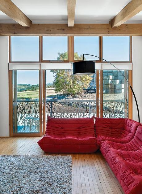 a lounge with a red couch and a view of the Scottish countryside