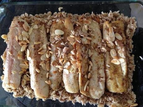 Lay the onion rice and top with fish fillets and nuts