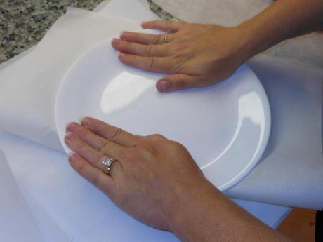 Next, using a large plate, I pressed down evenly on the ball in the parchment paper.