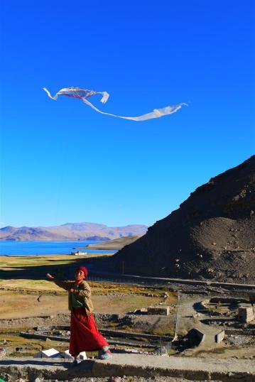 Little lama playing with his homemade kite, Korzok.