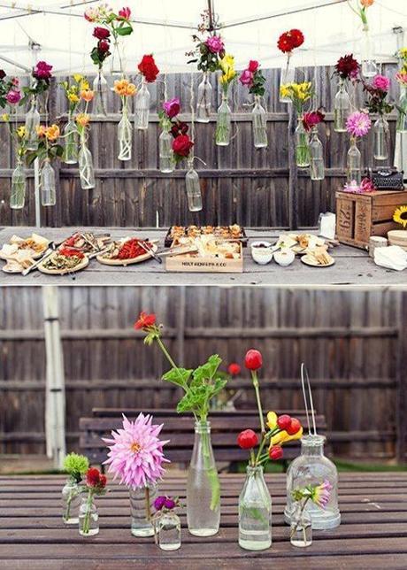 Flowers in Bottles Hung On Fence