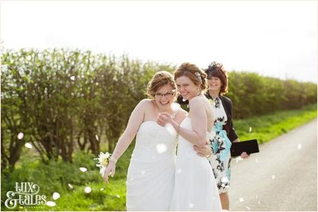 Laughing brides with confetti