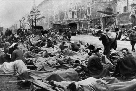 Vast throngs of wounded German soldiers crowd the streets as nurses attend to them.