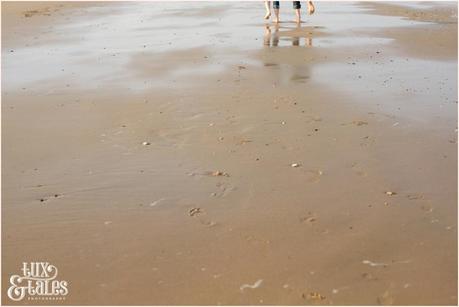 couple walks through the sand at Yorkshire beach