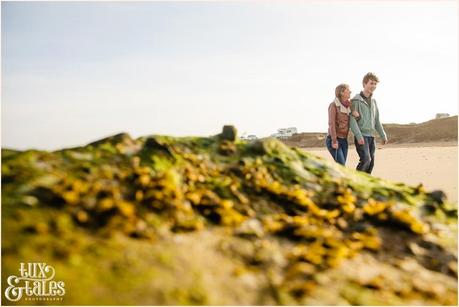 couple walks on the beach during engagement shoot