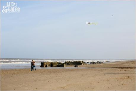 engaged couple fly a kite at Fraisthorpe beach