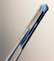Side view of a structural supercapacitor shows the blue polymer electrolyte that glues the silicon electrodes together