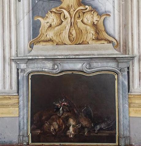 Painting of wild animals that have been hunted lying in the fireplace.
