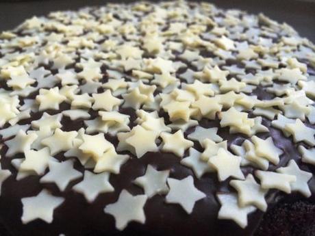 white chocolate stars liberally sprinkled onto dark chocolate fudge icing birthday cake food porn