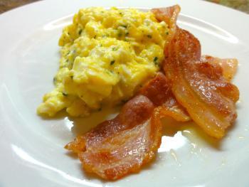 The Literary James Bond Scrambled eggs, prepared with herbs, and served with bacon.
