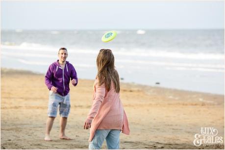 Tossing the frizbee at scarborough engagement photography session at the beach