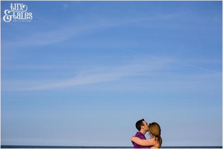 Scarborough engagement photography couple cuddling in front of blue sky