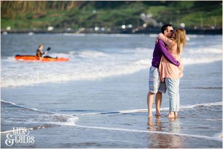 Couple hugging in the waves in North Beach engagement photography session