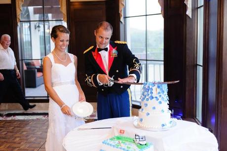Cutting military wedding cake with sword