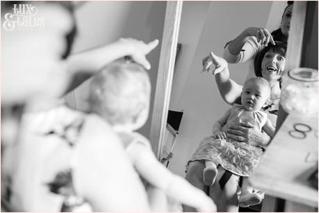 bride's mother holds baby as she has her hair styled