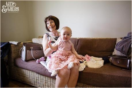 bride's mother dresses the brides daughter who is flower girl