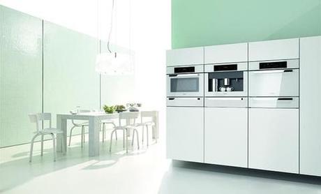 Pale green kitchen with modern appliances and table and chairs 