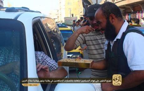 ISIS forced hand out sweets to welcoming civilians in a photo found on a jihadi forum.