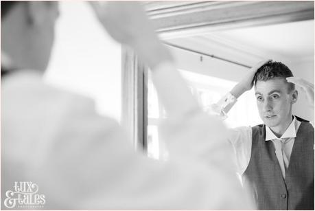 Groom preparation at yorkshire wedding looking inwindow