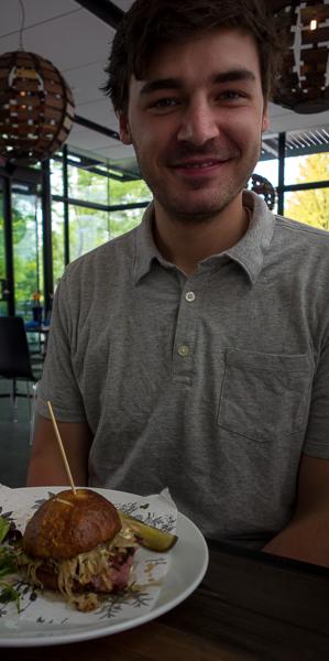 Phil with his pastrami sandwich, with sauerkraut, on a pretzel roll.