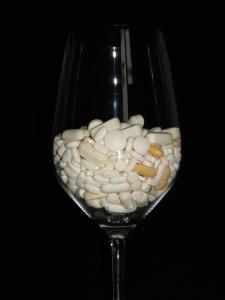 Image of wine glass filled with pills. 