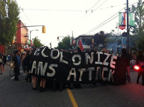Black bloc members de-bloc behind the banner before the rally dispersed.