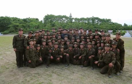 Kim Jong Un poses for a commemorative photo with service members and officers of the Hwa Islet Defense Detachment (Photo: Rodong Sinmun).