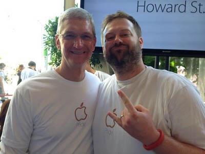Apple CEO Tim Cook (l) with an Apple employee making the Devil's horns handsign