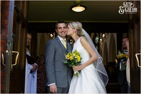 Bride kisses groom as they exit church