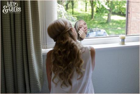 Bride puts on makeup at wedding preparation