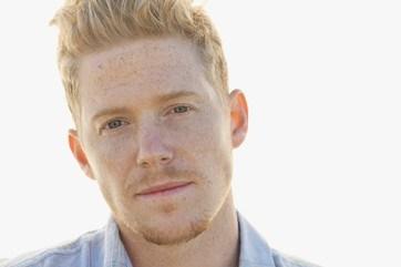 Close-up portrait of confident man with freckles