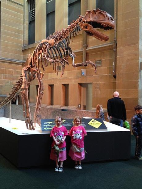 The girls at one of the skeleton remains of a dinosaur.