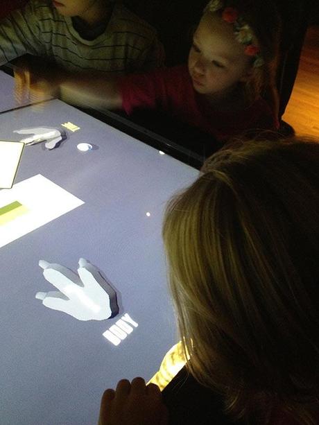 The girls playing with the touch screen.