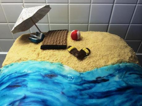 summer beach cake home-made parasol beach mat book ball and sandals