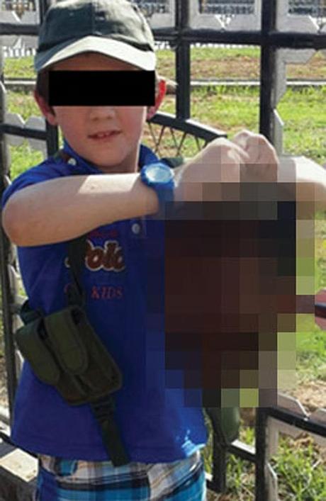 A boy, 7, believed to be the son of Australian Khaled Sharrouf holds the severed head of 