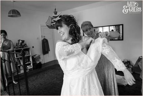 Bride gets into her lace wedding dress