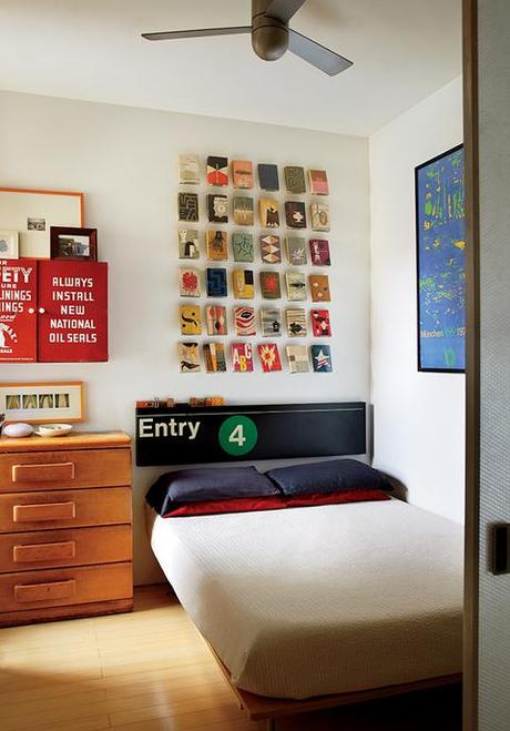 Renovated bedroom with vintage subway sign and book jackets on the wall