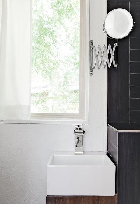 Minimal black and white bathroom with retractable mirror.