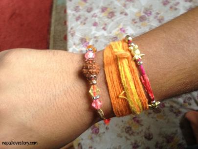 M's wrist filled with the threads and rakhis.