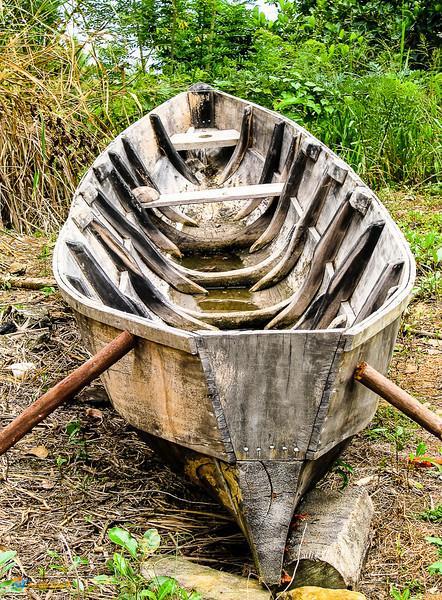 Handmade Carib canoe, drying along the side of the road