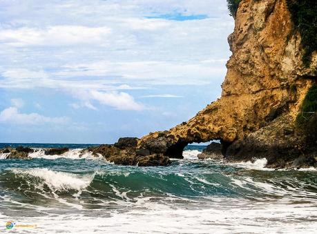 Black sand and arch at the far edge of Hampstead Beach